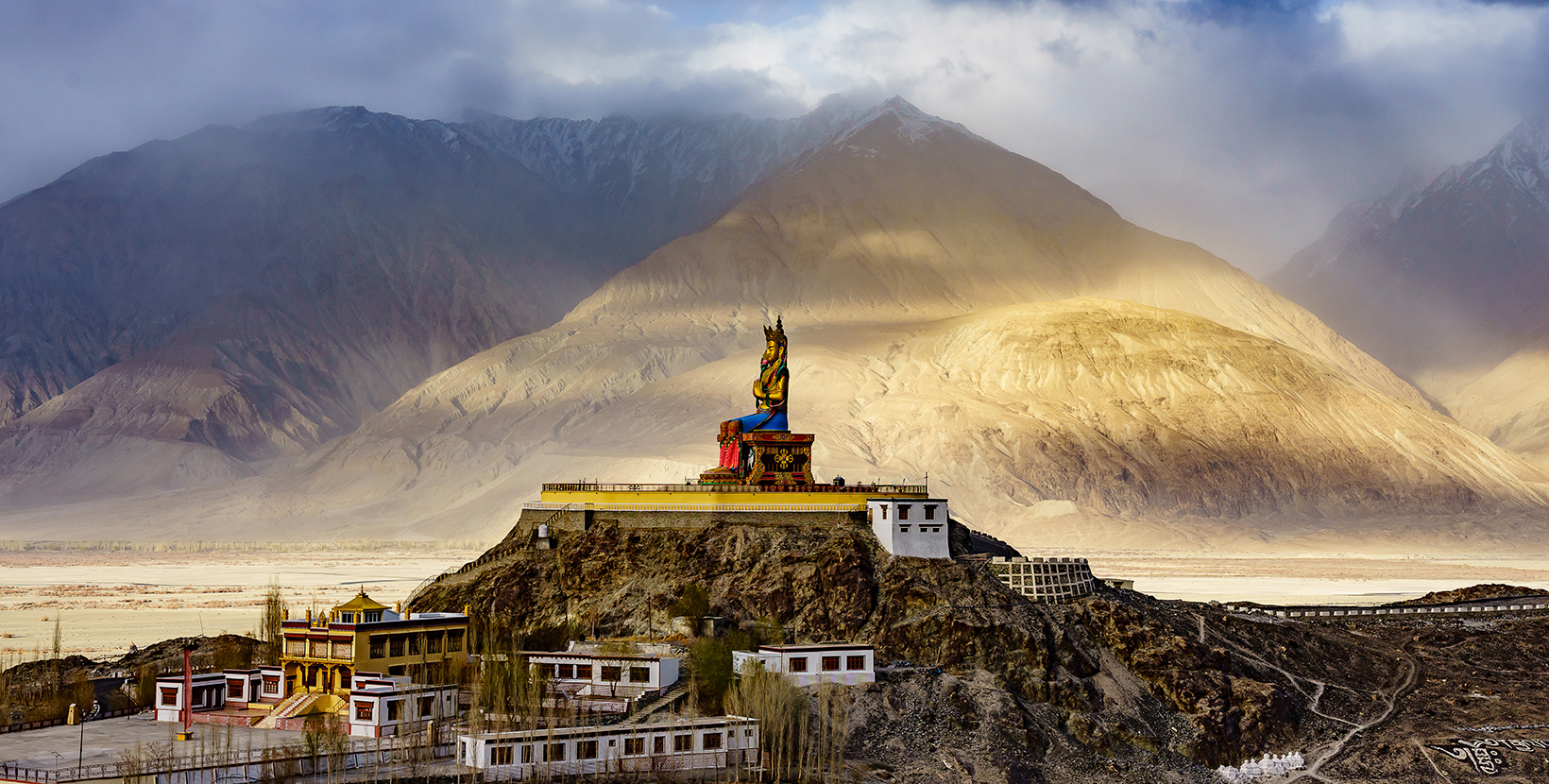 The Maitreya Buddha statue with Himalaya mountains in the background from Diskit Monastery or Diskit Gompa, Nubra valley, Leh Ladakh, Northen India.