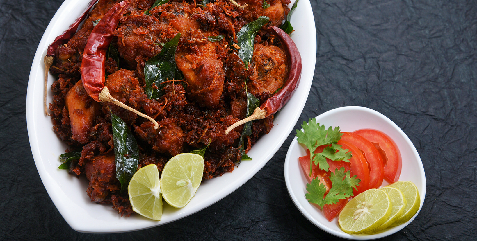 Andhra chicken fry or chicken 65 hot and spicy dish garnished with curry leaves Kerala. a popular authentic roasted dish deep fried in coconut oil  South India. fried in a coating of Indian spices.